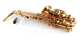 Saxophone alto doré posé sur une partition - guide d'achat pour débutants